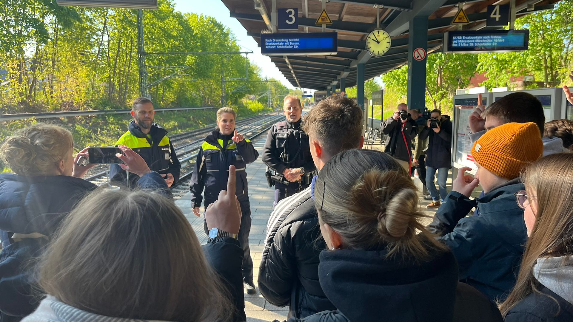 Das Präventionsteam erklärt den Schülern etwas am Bahnsteig.