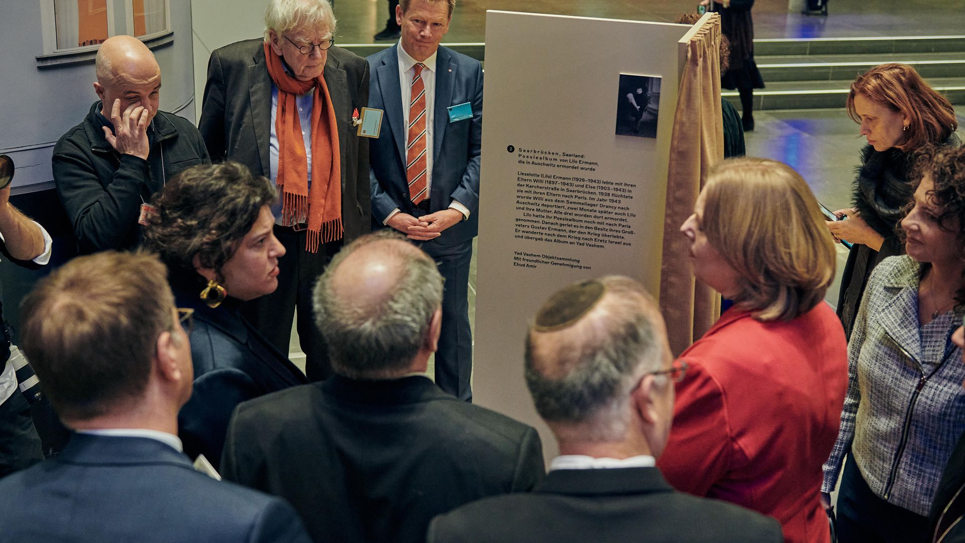 Menschen schauen sich eine Ausstellungsstele an