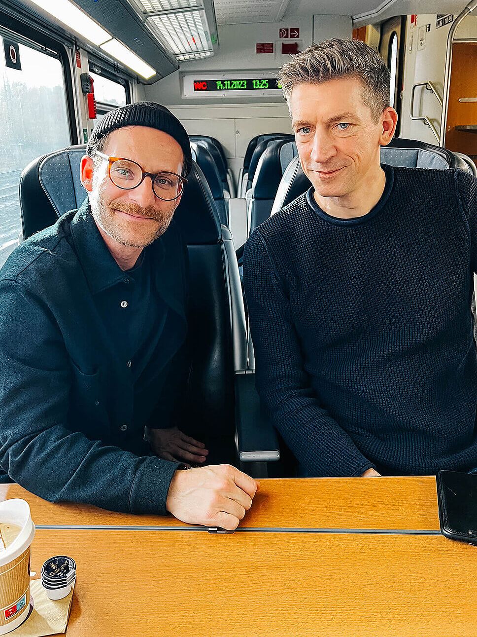 Steffen Hallaschka und Sebastian E. Merget im Zug