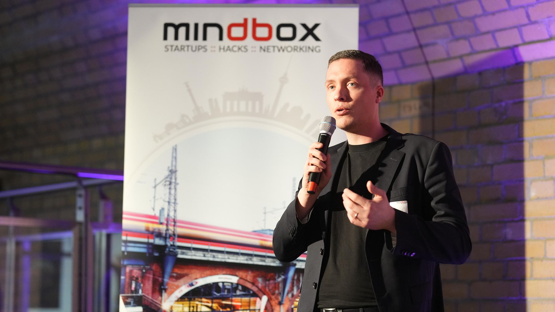 ein Mann spricht auf dem Podium ins Mikrofon