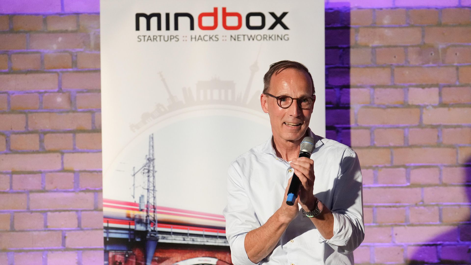 ein Mann spricht auf dem Podium ins Mikrofon