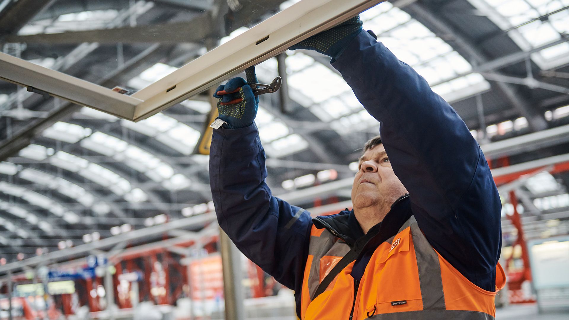 DB-Mitarbeiter repariert das Dach eines Unterstands