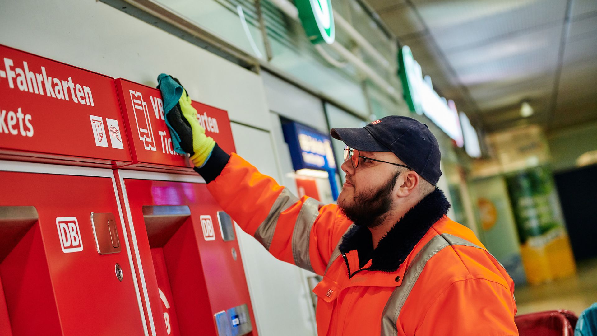 DB-Mitarbeiter säubert einen Fahrkartenautomaten