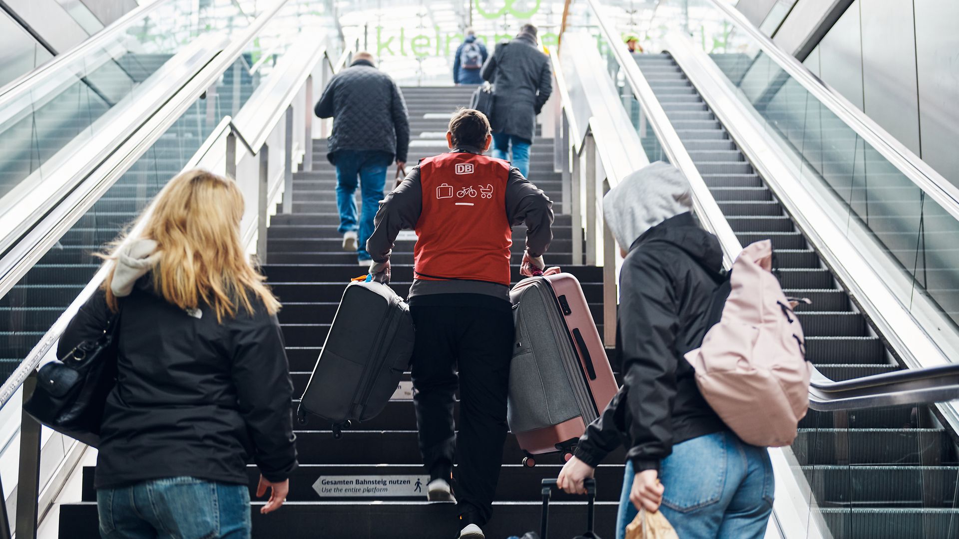 DB-Kofferträger auf einer Treppe am Hauptbahnhof Berlin