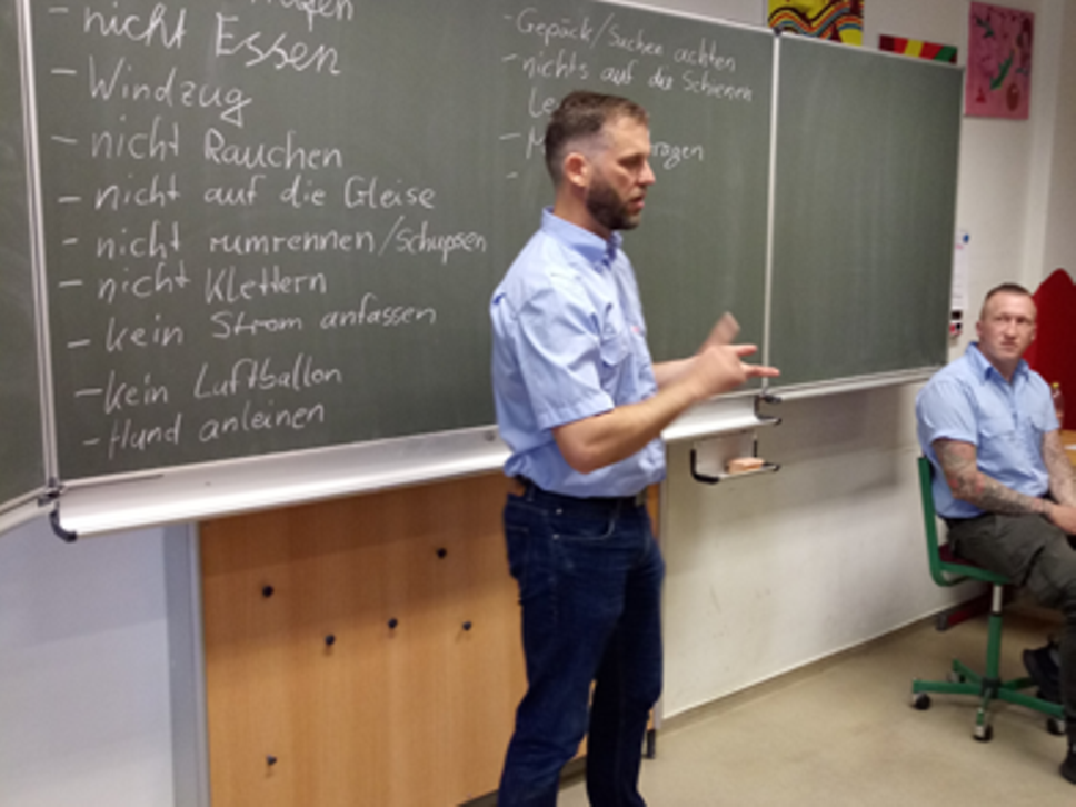 ein Polizist erklärt etwas vor der Tafel